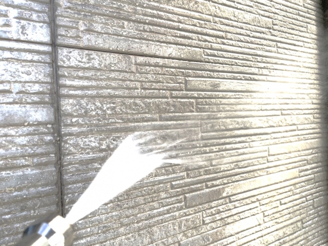 高圧洗浄で外壁の汚れを落とす様子